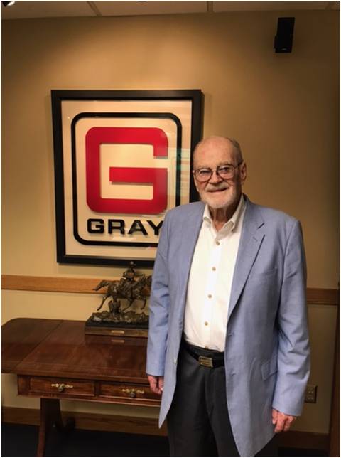 Joe Gray in front of the Gray logo